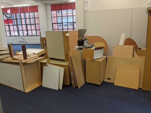 Dismantled office desks and pedestals stacked and ready for uplift during a commercial clearance